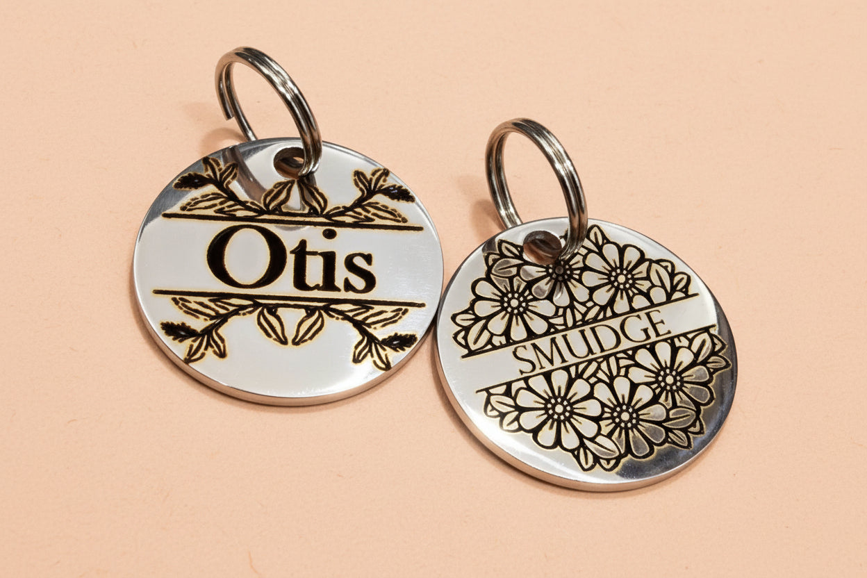 Two round metal dog tags with engraved names 