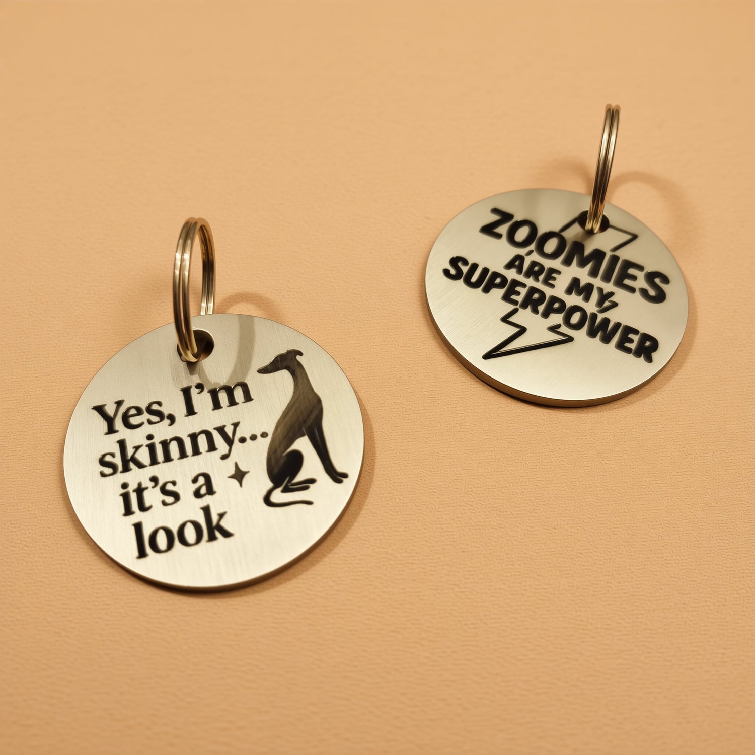 Two round metal tags with humorous text on them.