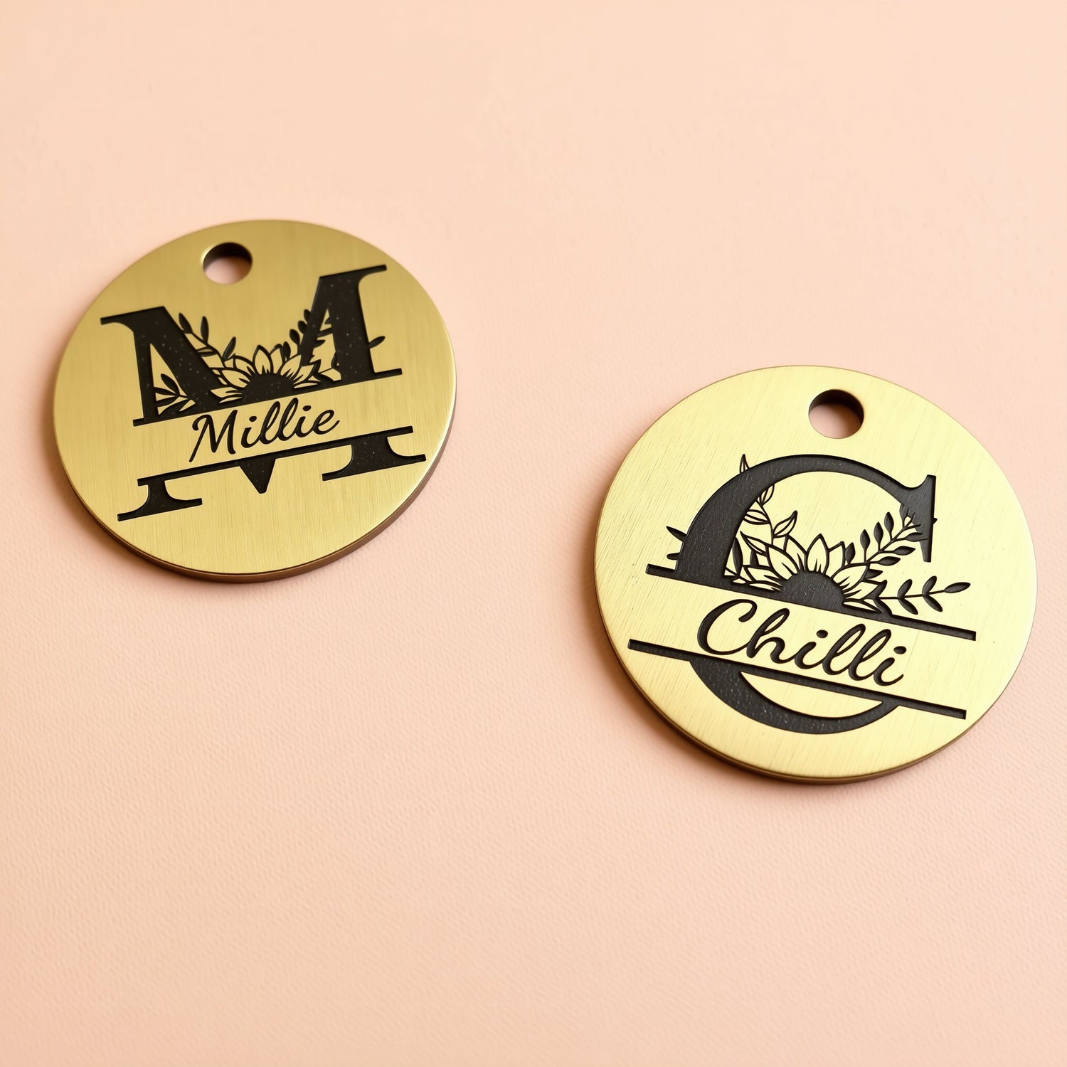 two round metal tags with personalized monogrammed names and floral designs.