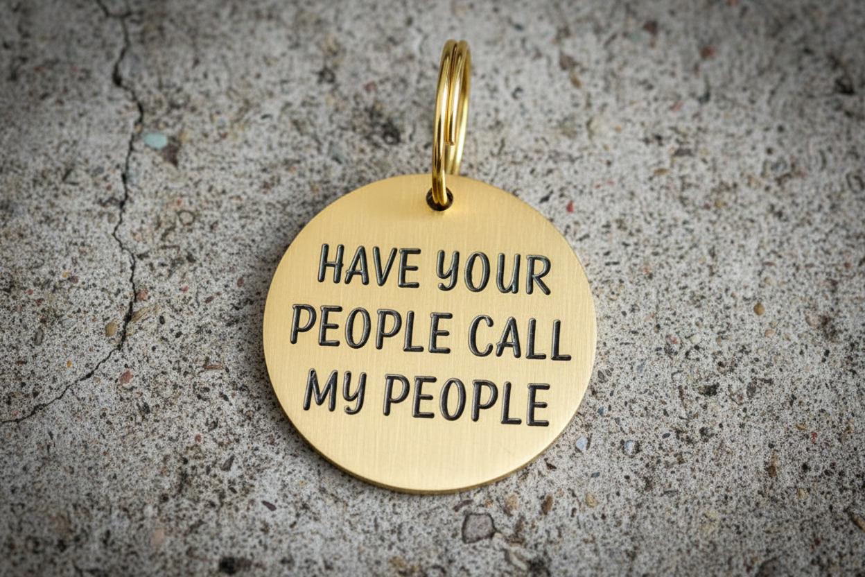 Gold dog ID tag with 'Have your people call my people' engraved on it